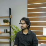 Portrait of a young professional in a modern office with wooden panel decor.